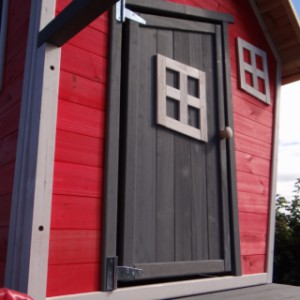 Het speelhuis Rosalie is voorzien van een scheve houten deur
