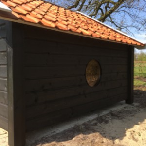 Houten schapenhok met dakpannen.