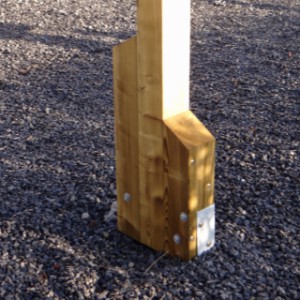 De houten schommelpalen staan vrij van de grond door de stevige grondankers in beton