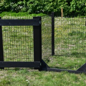 Zwrate houten poort met palen en zwart gaas