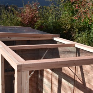 De volière heeft deels een gaasdak en deels een betonplex dak