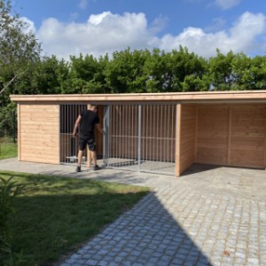 De hondenkennel Modul heeft een grote deur in het spijlenpaneel