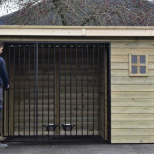 De deur van hondenkennel Modul FORZ draait naar binnen open, zodat de hond niet weg kan glippen