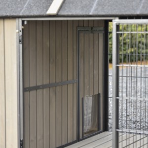 De opening van uit de ren naar het nachthok is voorzien van een lamellen deur