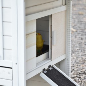 Het deurtje van het nachthok kan naar links en naar rechts geschoven worden