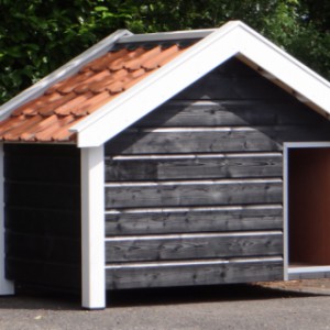 Een mooi hondenhok, de zwart/witte kleurstelling maakt dit hondenhok zeer stijlvol, de oranje dakpannen geven het hok een frisse kleur.